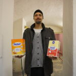 muž drží v každé ruce krabici, v jedné je sunar, v druhé sušené mléko